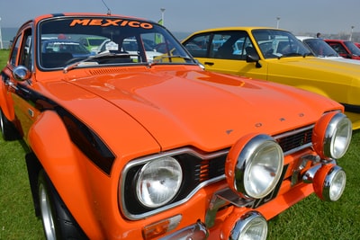 橘色和黑色的车在绿色的草地
